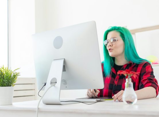 Illustrator, creative, web design concept - Female graphic designer with green hair at work